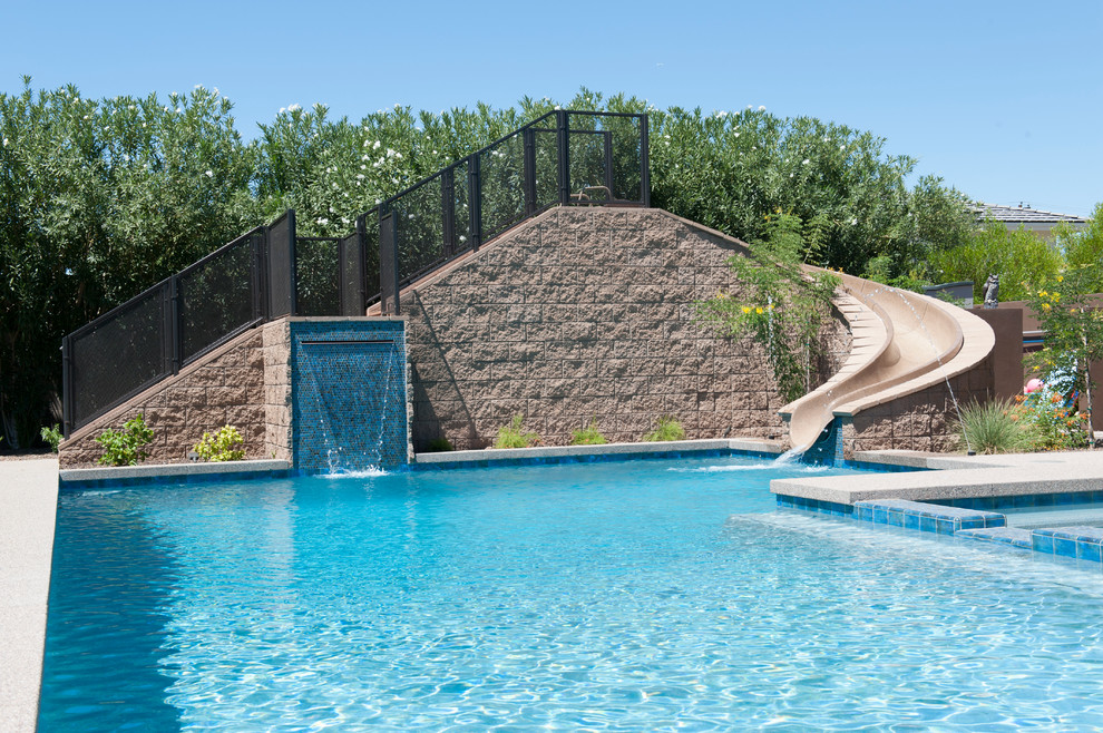 Idéer för en mellanstor modern pool på baksidan av huset, med marksten i betong och vattenrutschkana