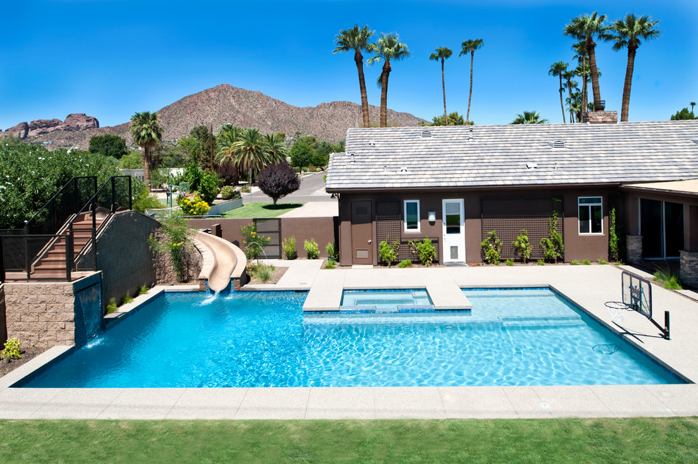 Mittelgroßer Moderner Pool hinter dem Haus in rechteckiger Form mit Wasserrutsche und Betonboden in Phoenix