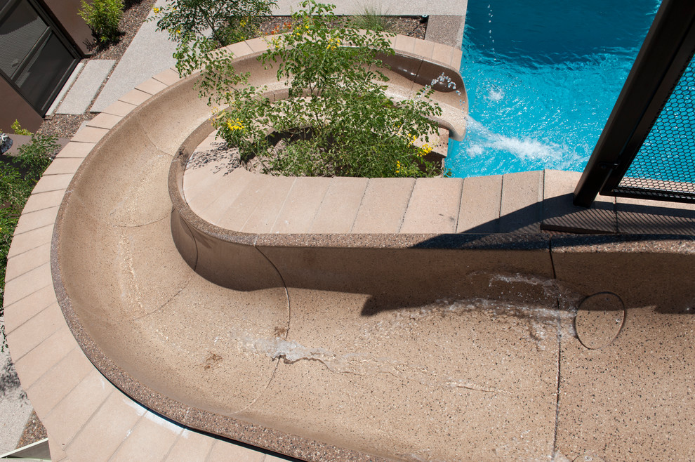Источник вдохновения для домашнего уюта: прямоугольный бассейн среднего размера на заднем дворе в современном стиле с водной горкой и мощением тротуарной плиткой