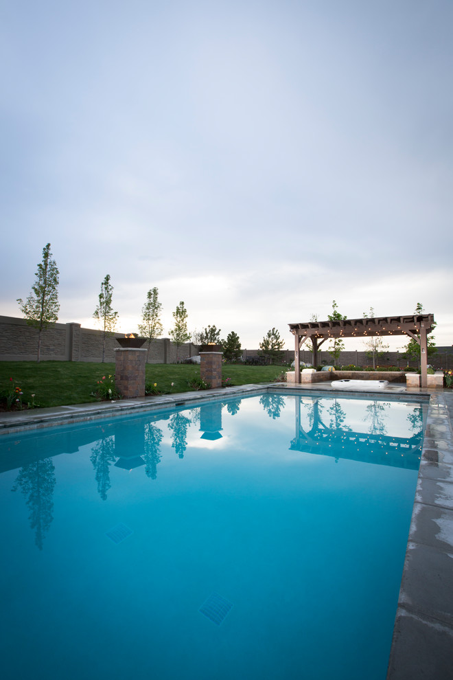 Idee per una grande piscina monocorsia classica rettangolare dietro casa con lastre di cemento