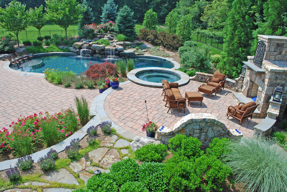 Example of a large classic backyard concrete paver and custom-shaped pool fountain design in DC Metro