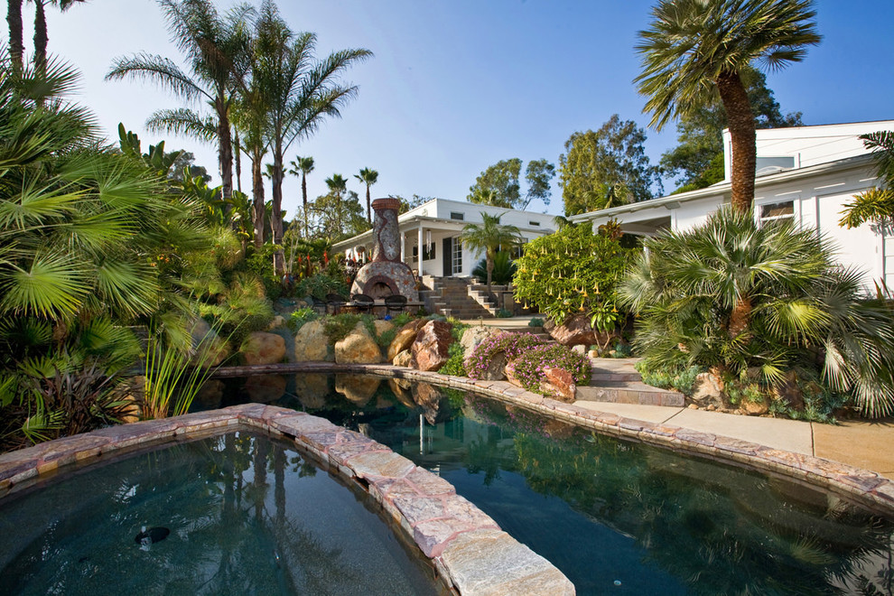 Hot tub - mid-sized tropical backyard concrete and custom-shaped hot tub idea in San Diego
