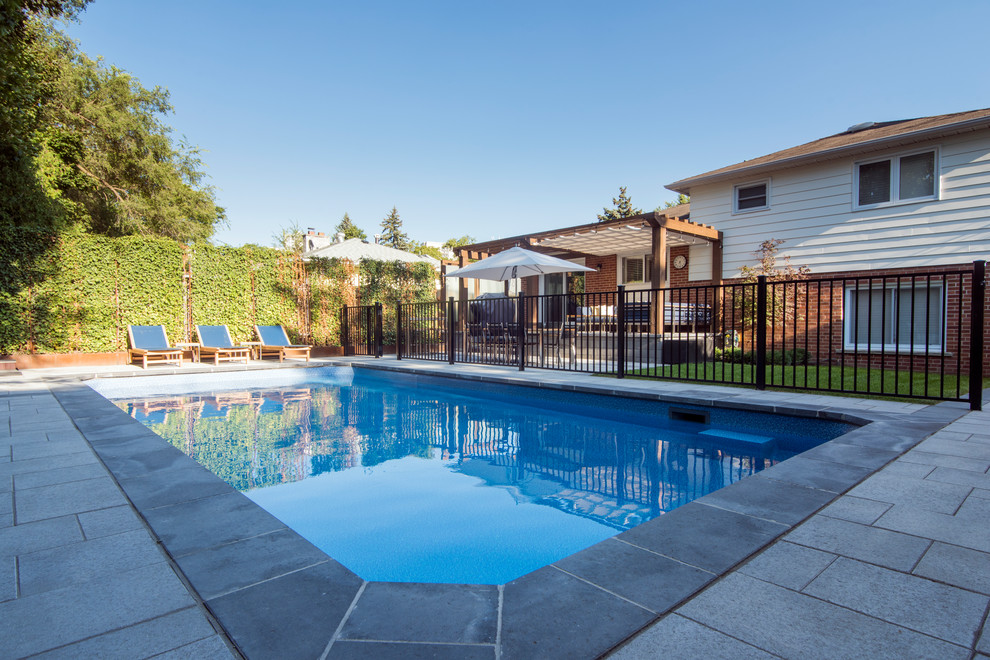Imagen de piscinas y jacuzzis alargados tradicionales grandes rectangulares en patio trasero con adoquines de hormigón