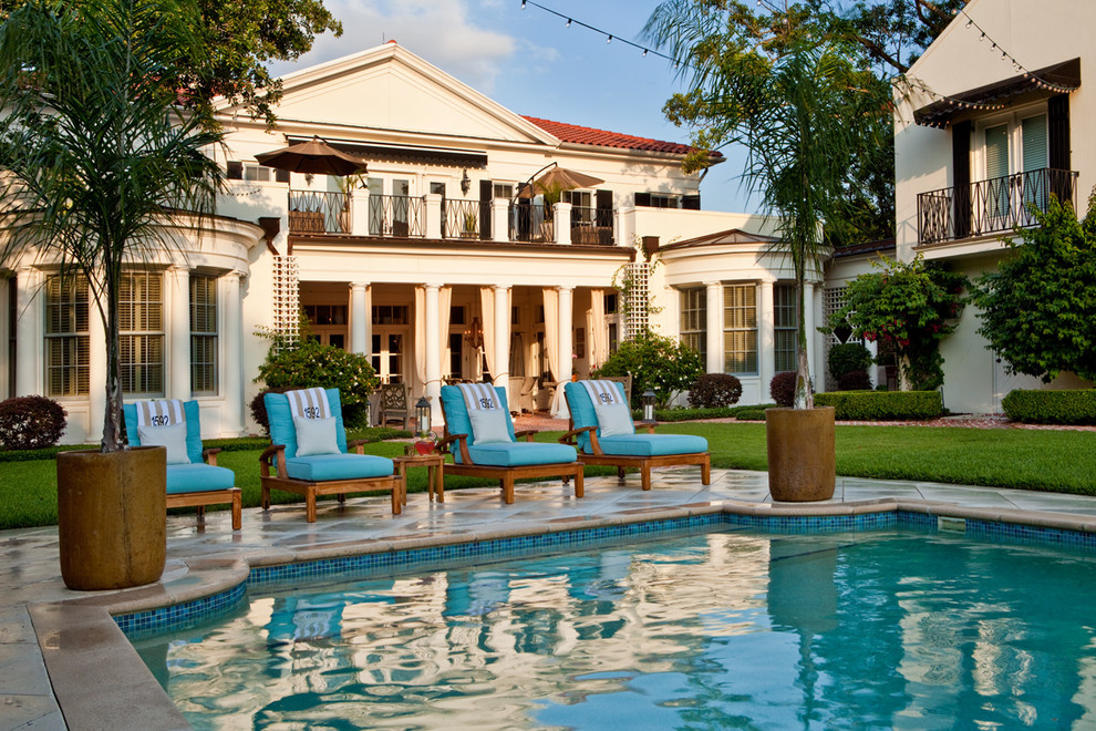 Diseño de piscina clásica rectangular en patio trasero con adoquines de hormigón