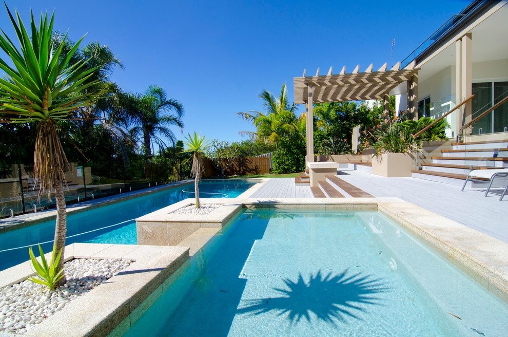 Immagine di una grande piscina monocorsia minimalista rettangolare dietro casa con fontane e pedane
