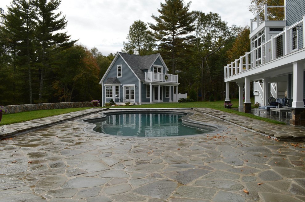Cette photo montre une grande piscine arrière montagne sur mesure avec des pavés en pierre naturelle.
