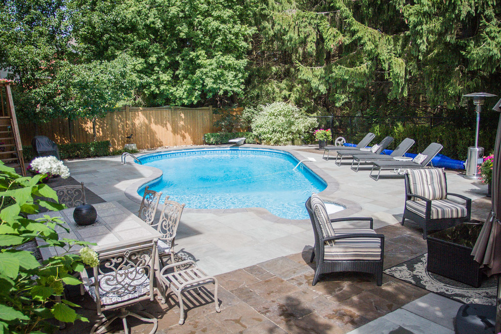 Esempio di una piscina monocorsia minimal rotonda dietro casa e di medie dimensioni con pavimentazioni in cemento