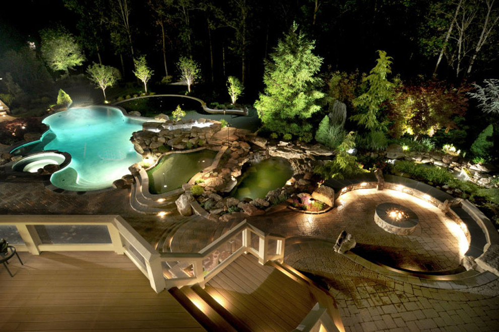 Modelo de piscinas y jacuzzis naturales contemporáneos extra grandes a medida en patio trasero con adoquines de hormigón