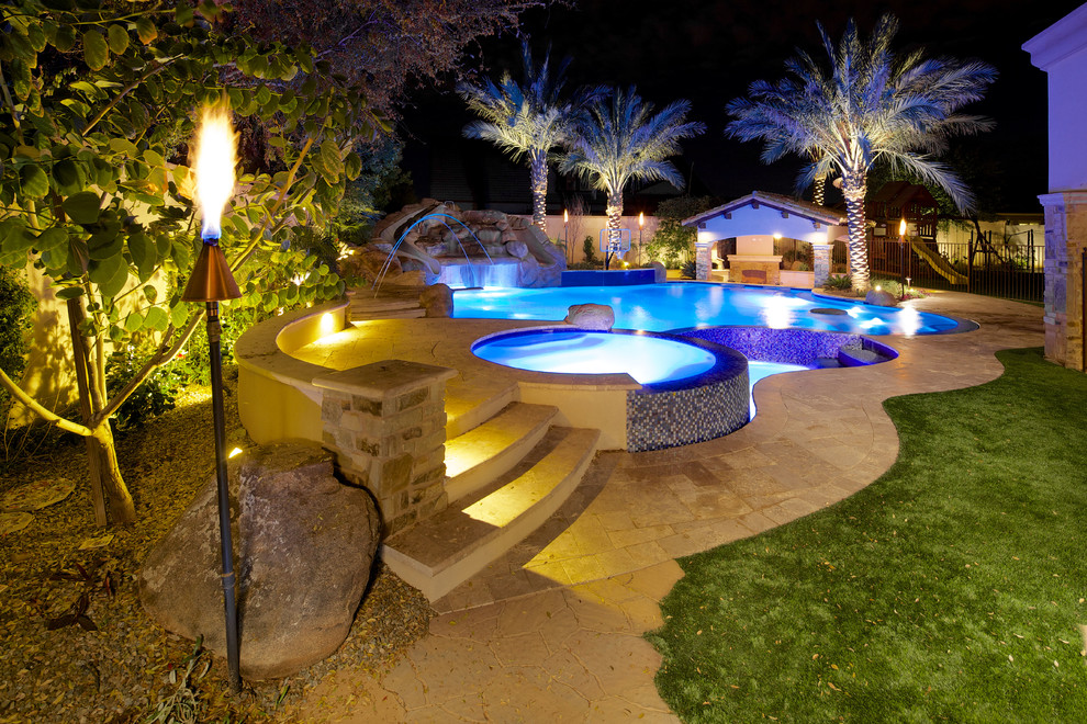 Пример оригинального дизайна: большой естественный бассейн произвольной формы на заднем дворе в средиземноморском стиле с покрытием из каменной брусчатки