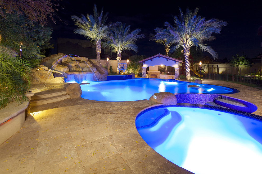 Example of a large tuscan backyard stone and custom-shaped natural pool design in Phoenix