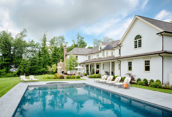 Immagine di una grande piscina monocorsia classica rettangolare dietro casa con pavimentazioni in pietra naturale e una vasca idromassaggio