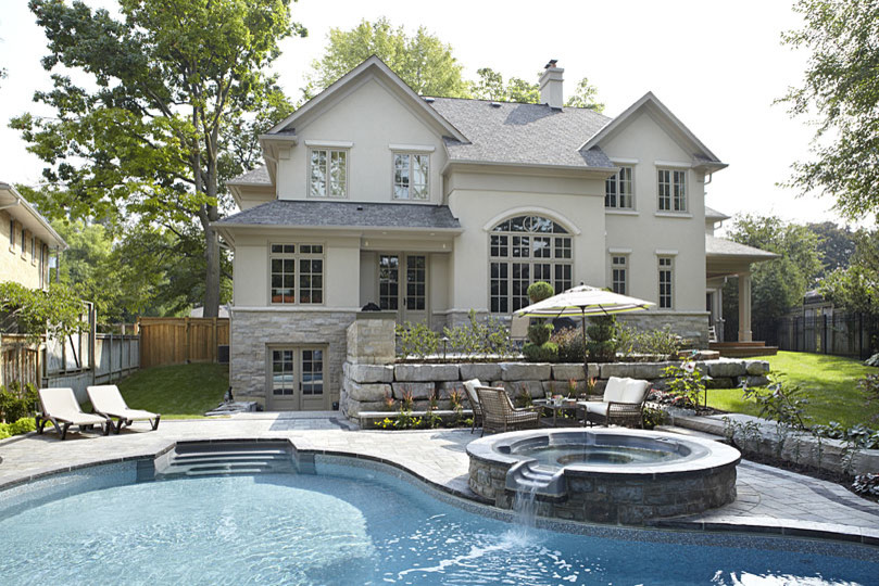 Esempio di una grande piscina naturale minimal personalizzata dietro casa con fontane e pavimentazioni in mattoni