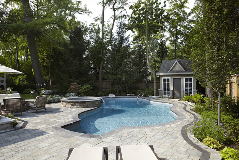 Großer Moderner Schwimmteich hinter dem Haus in individueller Form mit Wasserspiel und Pflastersteinen in Toronto