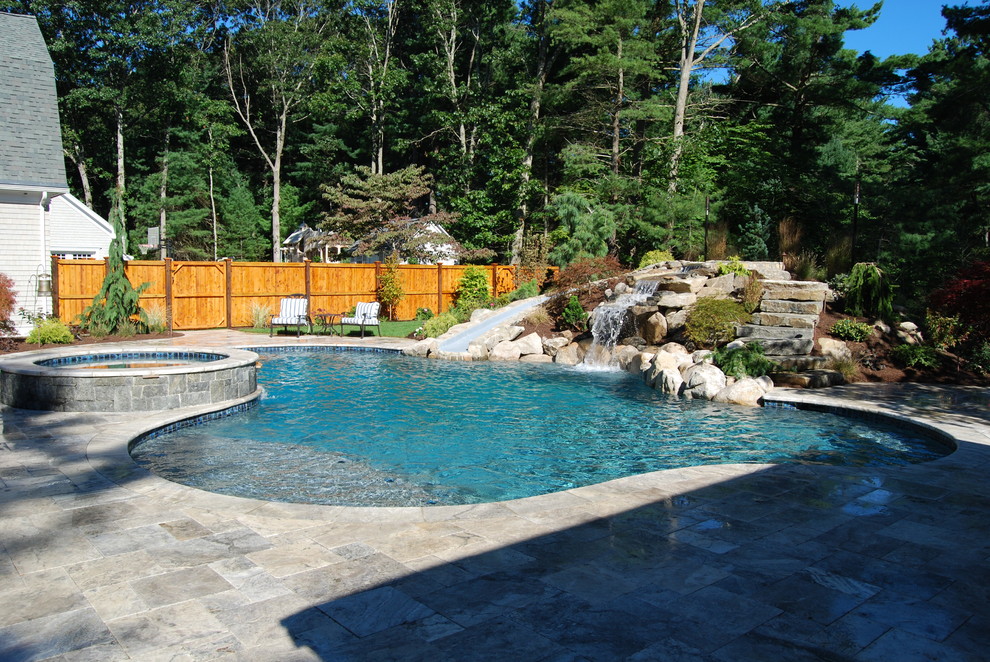 Diseño de piscina con tobogán natural rural de tamaño medio tipo riñón en patio trasero con adoquines de piedra natural