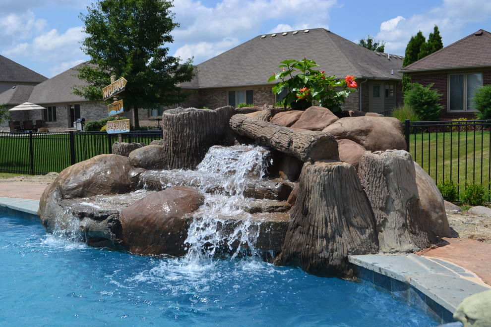 Diseño de piscina con fuente natural actual de tamaño medio a medida en patio trasero