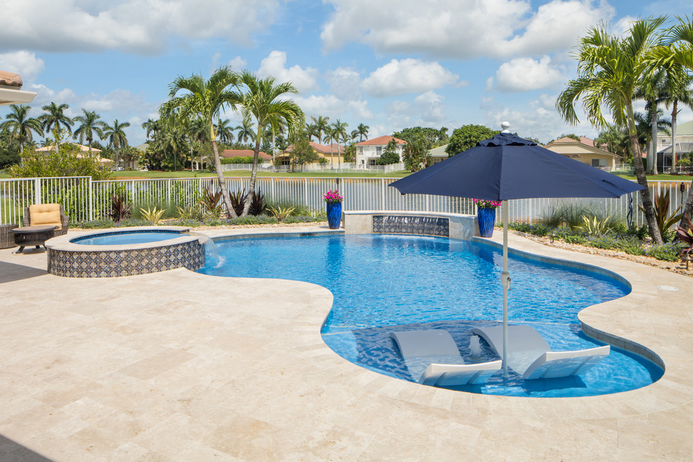 Ispirazione per una piscina naturale moderna personalizzata di medie dimensioni e dietro casa con pavimentazioni in pietra naturale