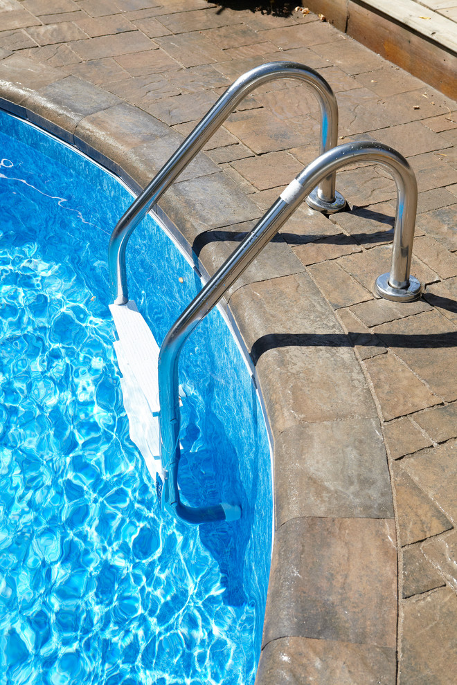 Esempio di una grande piscina naturale contemporanea personalizzata dietro casa con fontane e pavimentazioni in mattoni