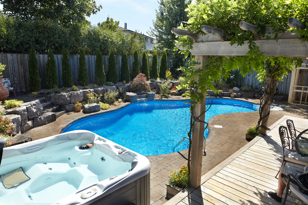 Foto di una grande piscina naturale minimal personalizzata dietro casa con fontane e pavimentazioni in mattoni