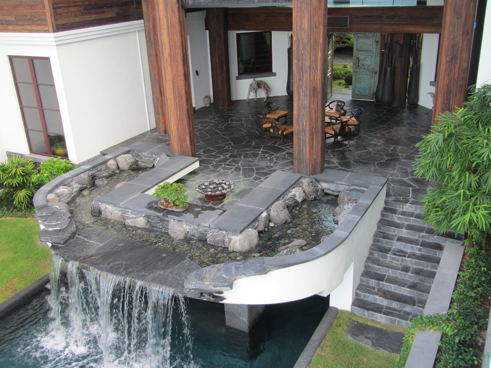 Esempio di una grande piscina contemporanea rettangolare dietro casa con pavimentazioni in pietra naturale
