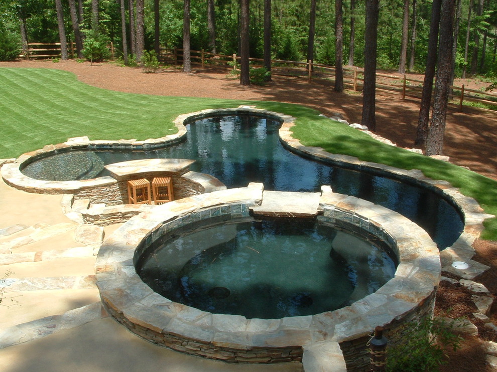 Foto de piscinas y jacuzzis elevados de estilo americano de tamaño medio a medida en patio trasero con adoquines de piedra natural