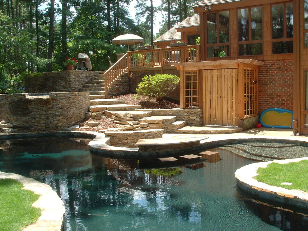 Imagen de piscinas y jacuzzis elevados de estilo americano de tamaño medio a medida en patio trasero con adoquines de piedra natural