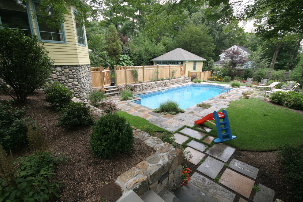Ejemplo de piscina natural contemporánea a medida en patio trasero con adoquines de piedra natural