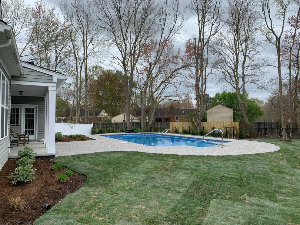 Idee per una piscina naturale tradizionale rettangolare di medie dimensioni e dietro casa con paesaggistica bordo piscina e pavimentazioni in cemento