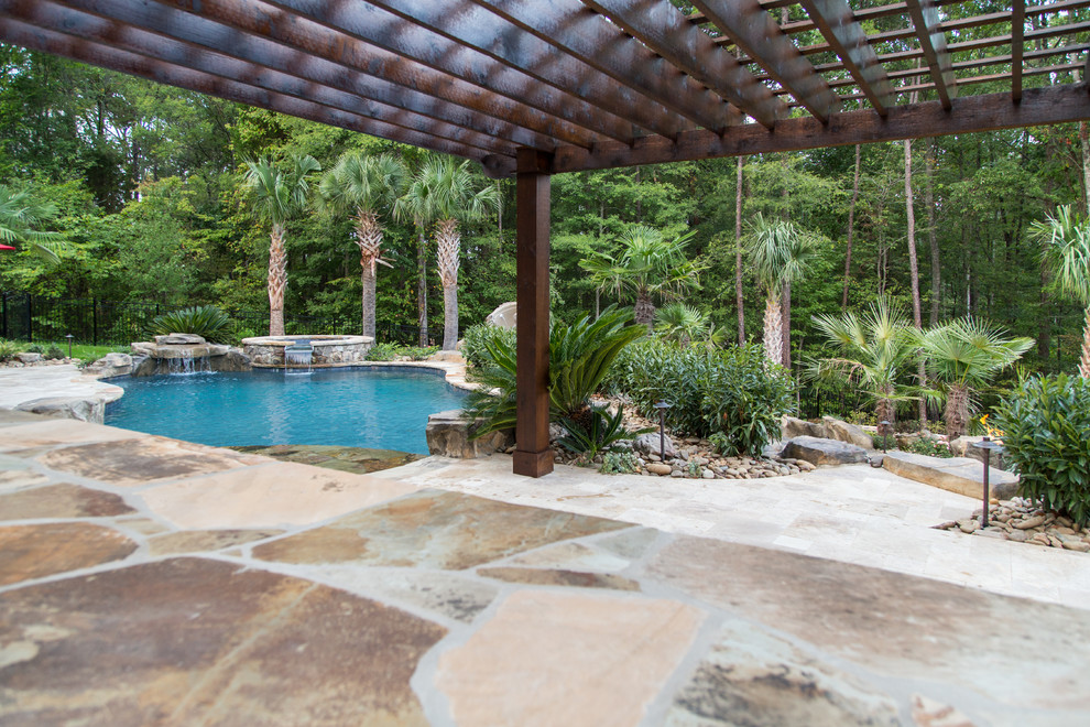 Huge island style backyard stone and custom-shaped pool fountain photo in Charlotte