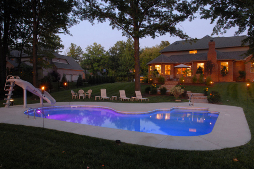 Идея дизайна: угловой бассейн среднего размера на заднем дворе в современном стиле с покрытием из бетонных плит и водной горкой