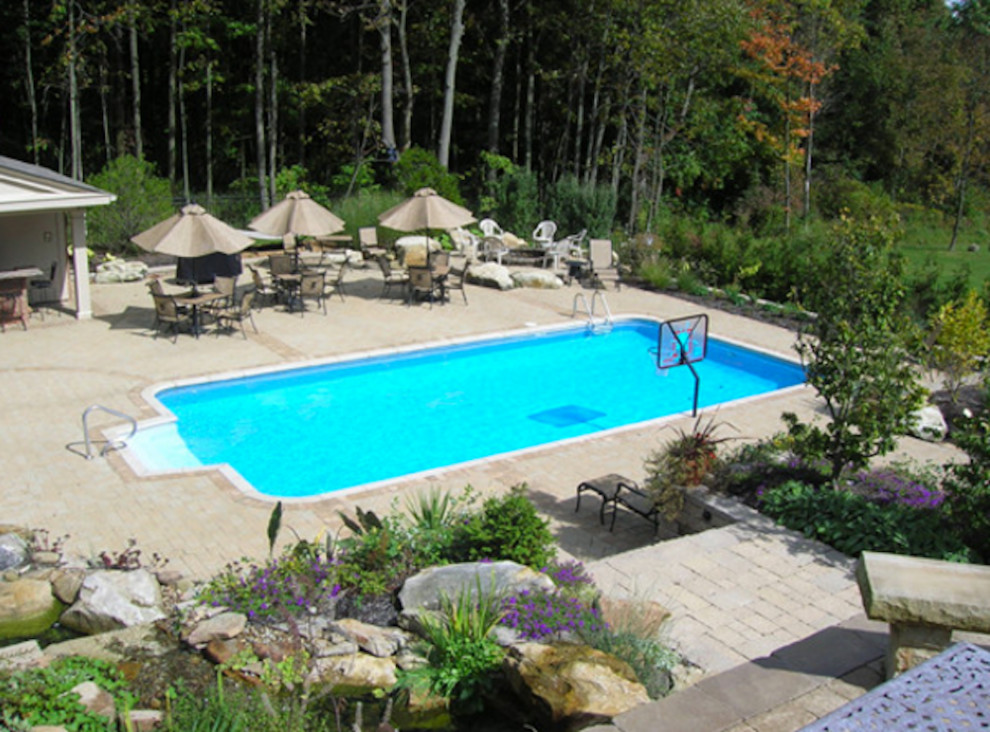 Idee per una grande piscina monocorsia chic rettangolare dietro casa con pavimentazioni in cemento