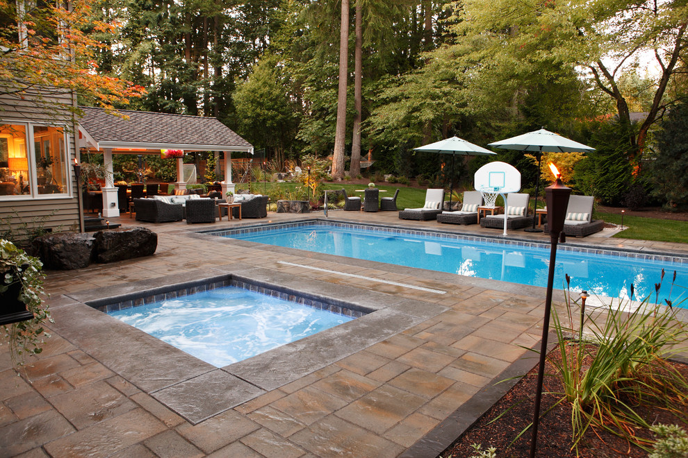 Großer Moderner Pool hinter dem Haus in rechteckiger Form mit Natursteinplatten in Seattle
