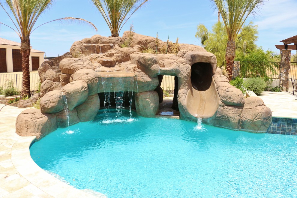 Foto de piscina con fuente alargada actual grande rectangular en patio trasero con adoquines de piedra natural