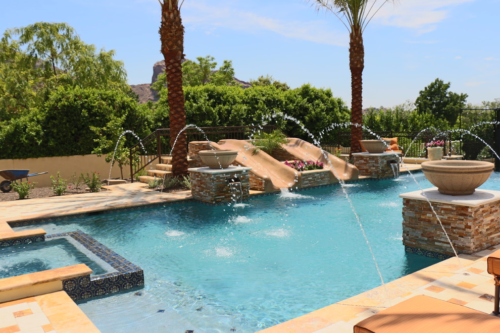Large trendy backyard stone and rectangular lap water slide photo in Phoenix