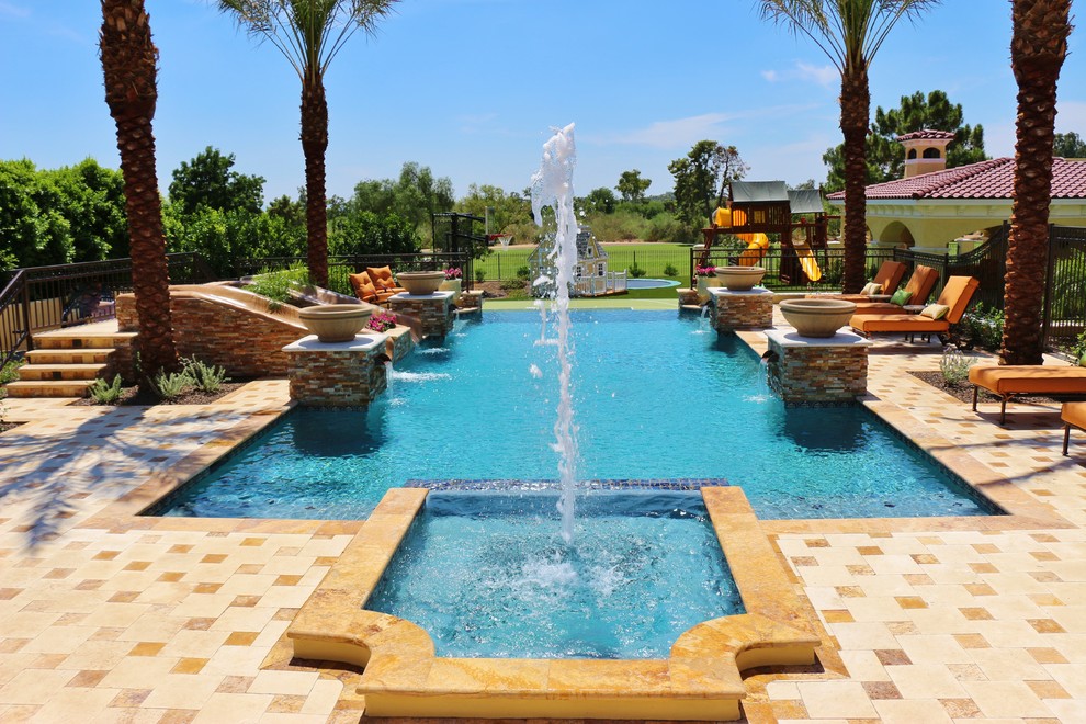 Modelo de piscinas y jacuzzis alargados clásicos de tamaño medio rectangulares en patio trasero con adoquines de piedra natural