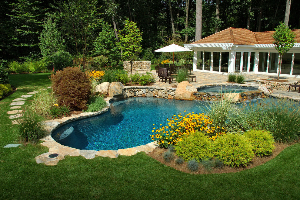 Foto de piscinas y jacuzzis de estilo de casa de campo grandes a medida en patio trasero con adoquines de piedra natural