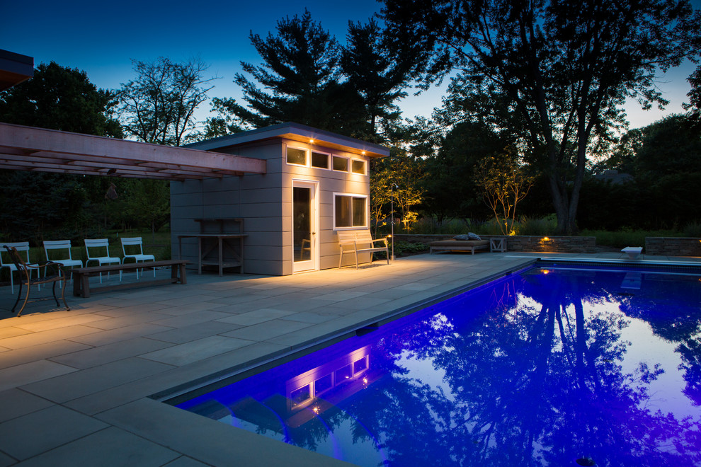 Aménagement d'une piscine arrière moderne de taille moyenne et rectangle avec des pavés en pierre naturelle.