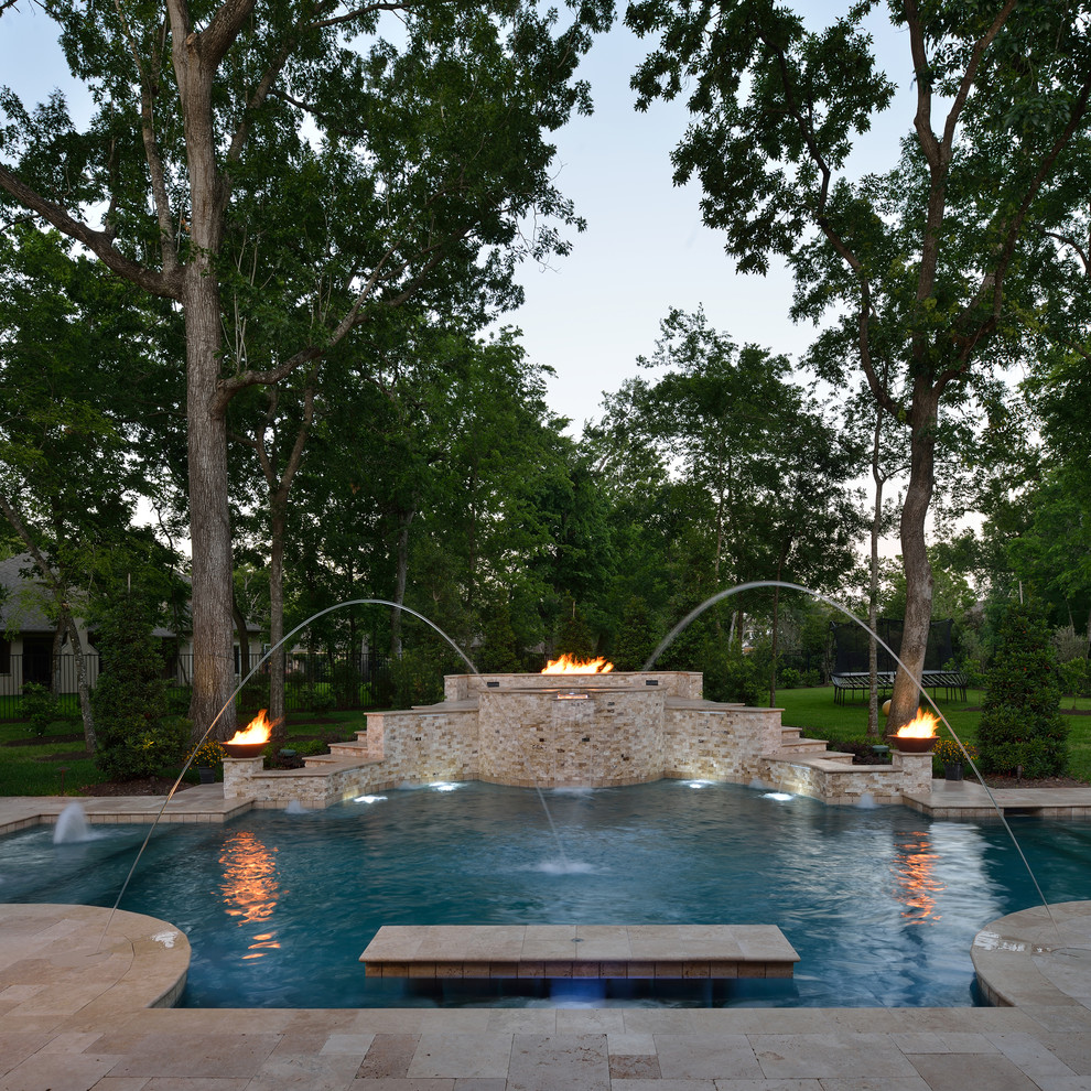 Cette image montre une très grande piscine naturelle et arrière traditionnelle sur mesure avec des pavés en pierre naturelle et un bain bouillonnant.