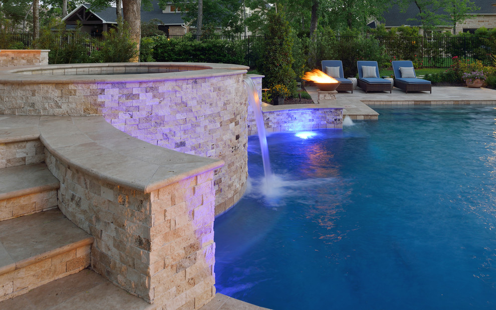 Immagine di un'ampia piscina naturale tradizionale personalizzata dietro casa con pavimentazioni in pietra naturale e una vasca idromassaggio