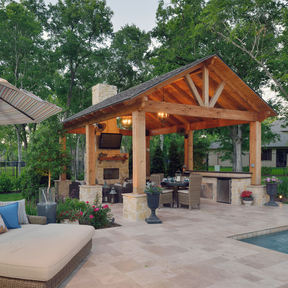 Inspiration for a large transitional backyard stone patio remodel in Houston with an awning