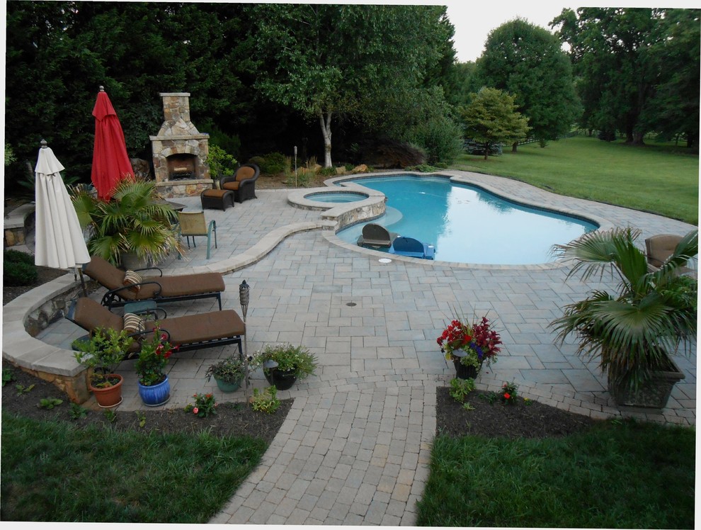 Design ideas for a large traditional back custom shaped hot tub in DC Metro with natural stone paving.