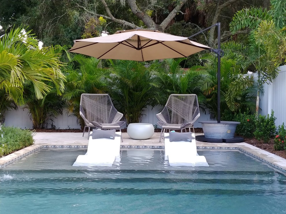 Idee per una piscina moderna personalizzata di medie dimensioni e dietro casa con pavimentazioni in pietra naturale
