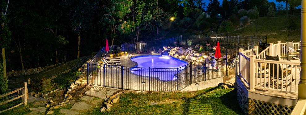 Idee per una piscina classica personalizzata di medie dimensioni e dietro casa con pavimentazioni in pietra naturale e una vasca idromassaggio