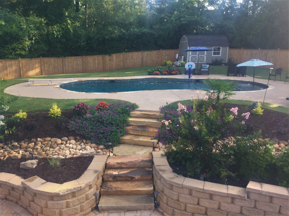 Expansive classic back custom shaped swimming pool in Atlanta with decking.