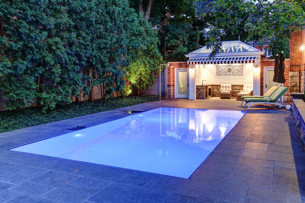 Immagine di una piccola piscina a sfioro infinito chic rettangolare dietro casa con una dépendance a bordo piscina e pavimentazioni in pietra naturale