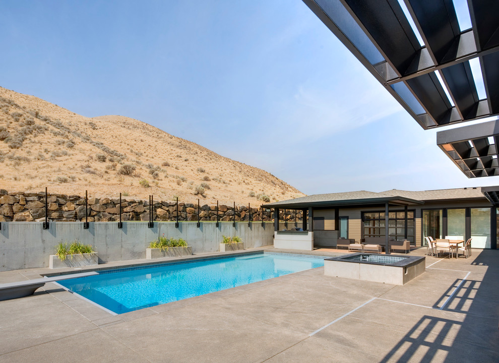 Diseño de piscina actual rectangular en patio con losas de hormigón