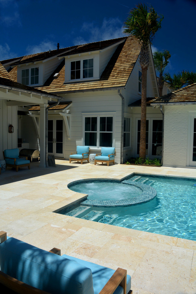 Réalisation d'une piscine arrière tradition de taille moyenne et rectangle avec des pavés en pierre naturelle.