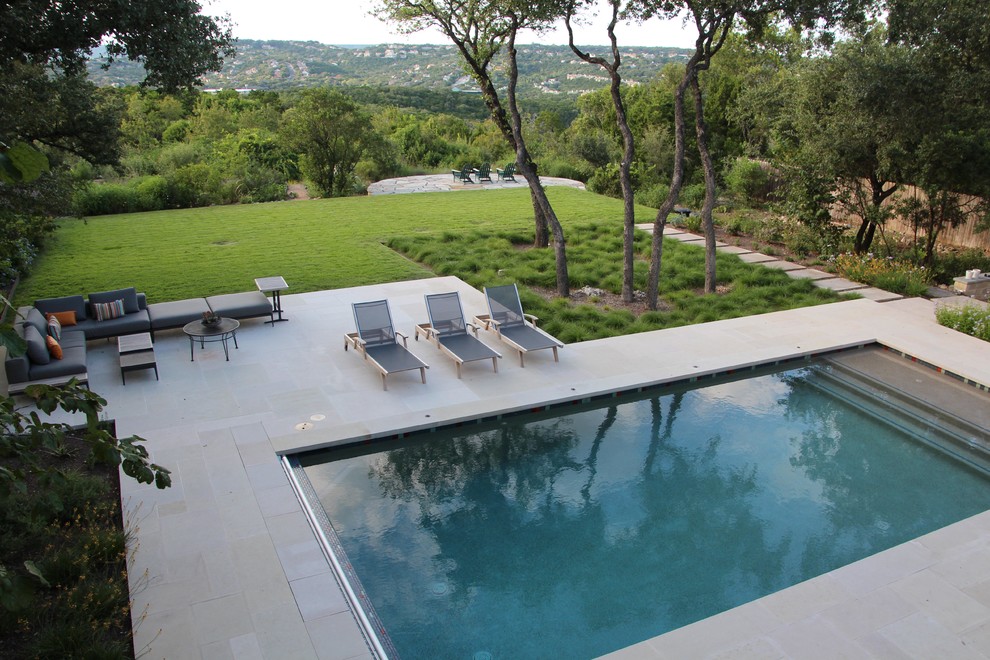 Inspiration for a large modern back rectangular lengths swimming pool in Austin with a water feature and concrete paving.