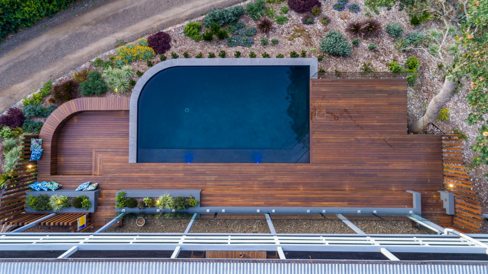 Immagine di una piscina country personalizzata di medie dimensioni e dietro casa con paesaggistica bordo piscina e pedane