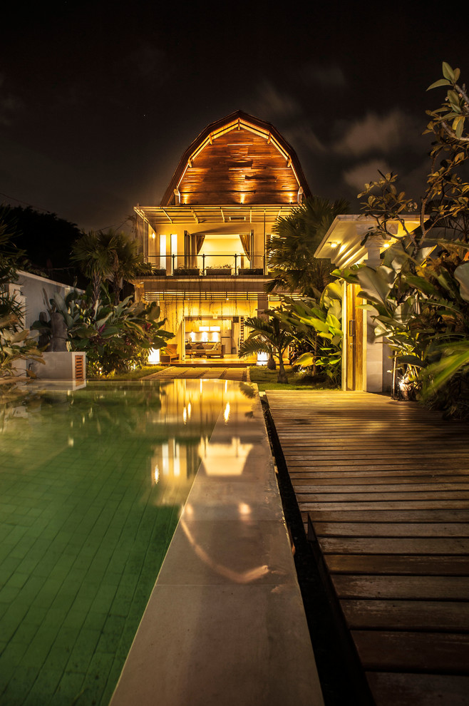 Réalisation d'un très grand Abris de piscine et pool houses arrière asiatique sur mesure avec une terrasse en bois.