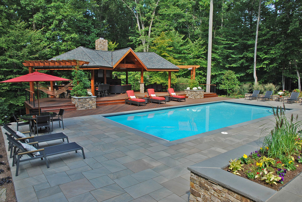 Ispirazione per una grande piscina naturale etnica rettangolare dietro casa con una dépendance a bordo piscina e pavimentazioni in pietra naturale